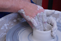 Ceramic student hands working at potting wheel 