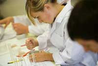 Science students in lab coats conducting experiment 